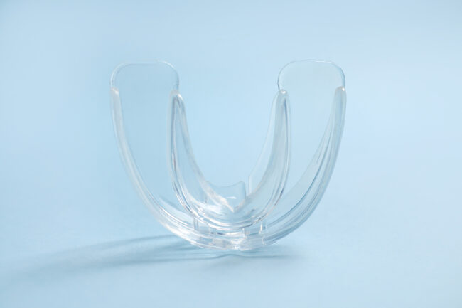 Dental Mouth Guard On Light Blue Background, Closeup. Bite Corre